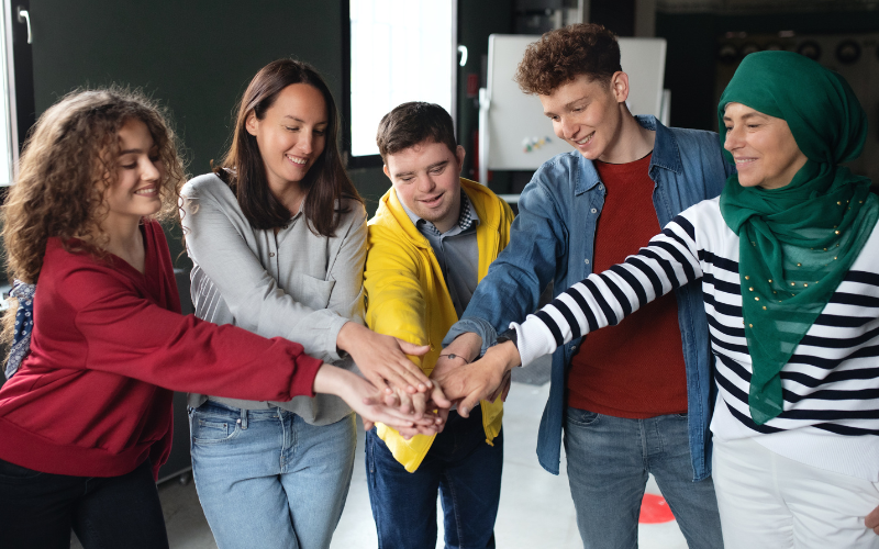 Team of adults with hands together